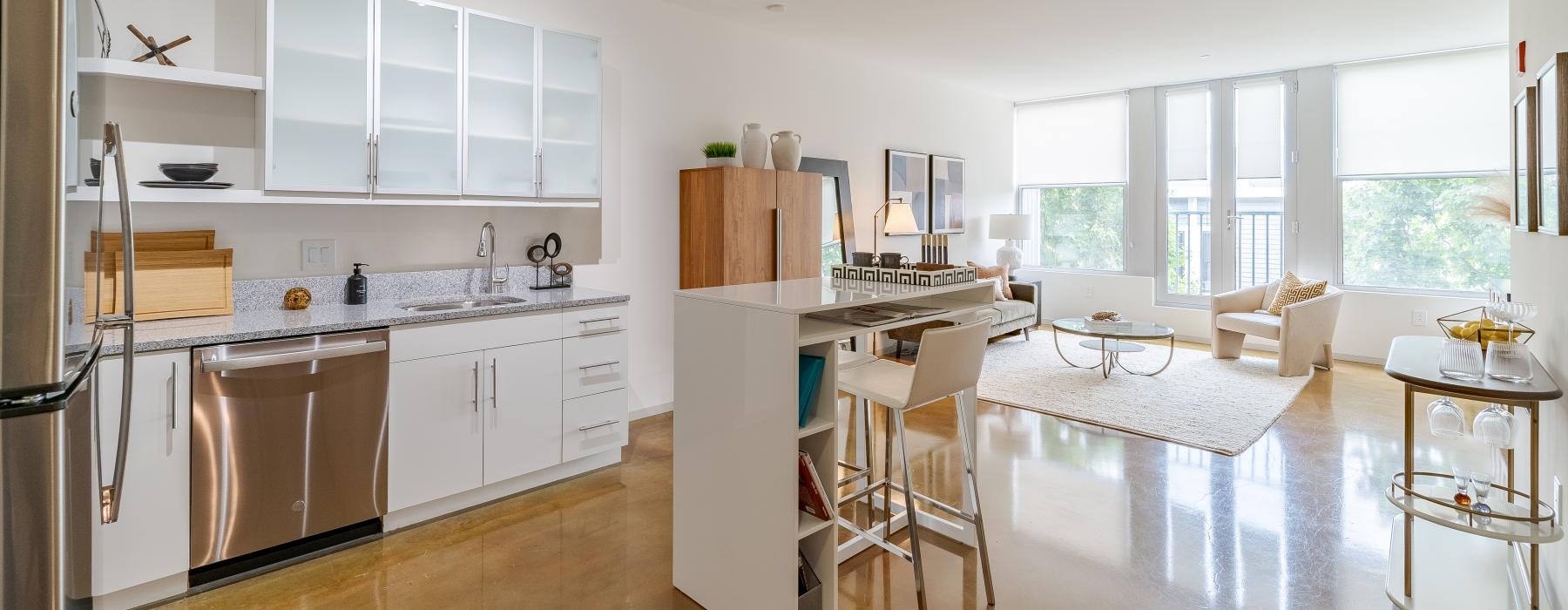 a kitchen with white cabinets and many windows
